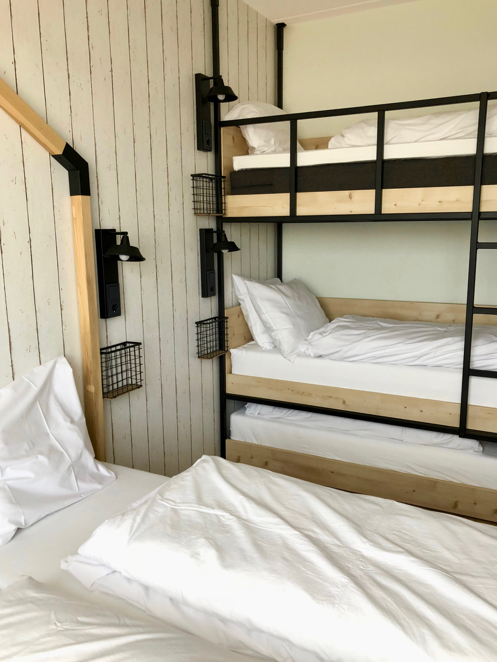 Hotelkamer met tweepersoons bed en stoer stapelbed